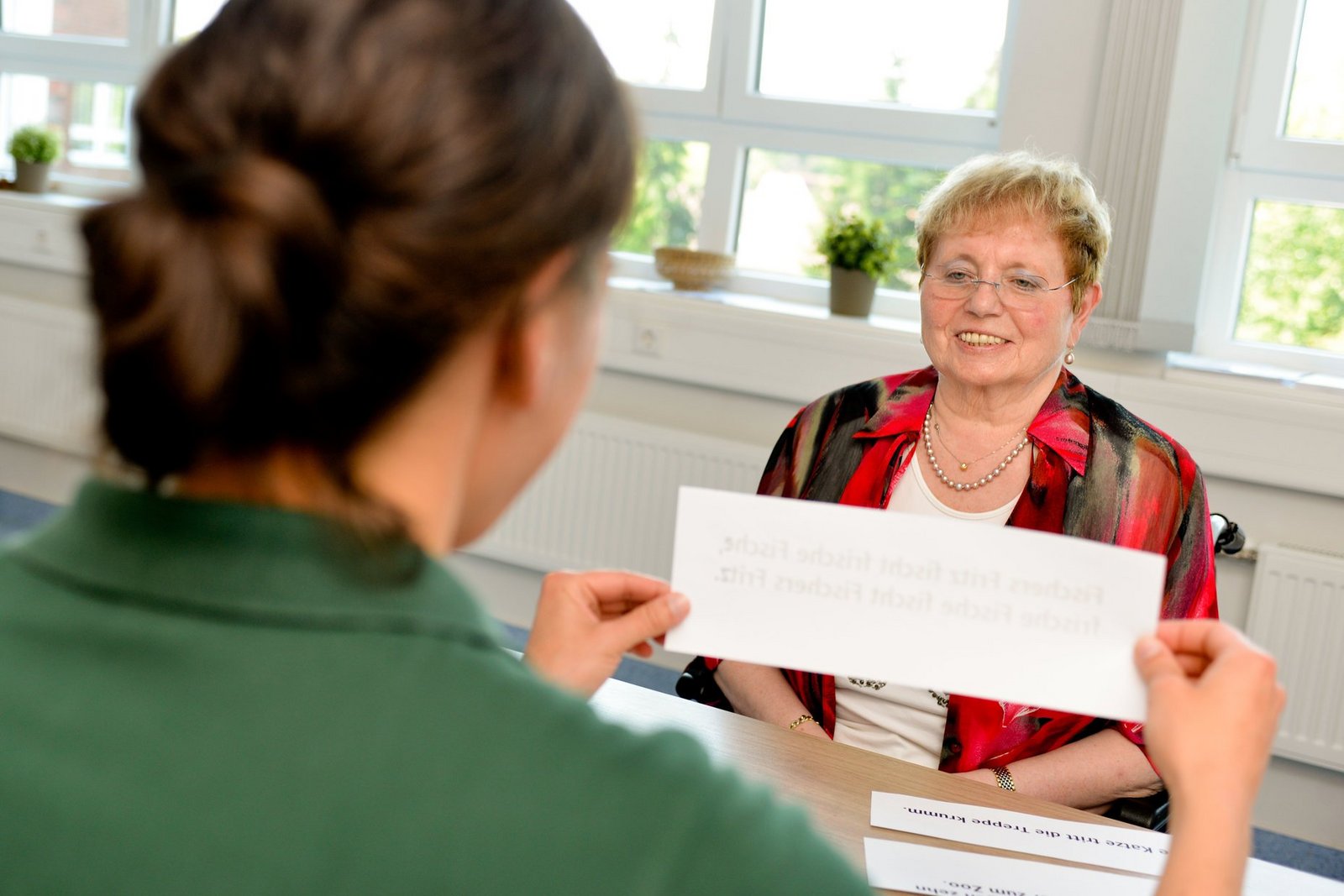 Patientinn und Therapeutin machen logopädische Übungen